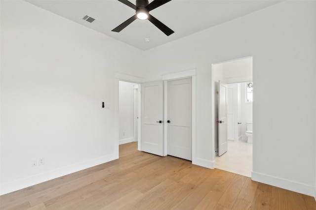 unfurnished bedroom with light wood-type flooring, ensuite bathroom, and ceiling fan