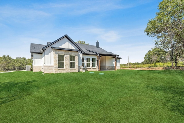 rear view of property featuring a lawn