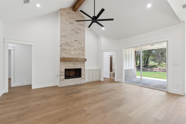 unfurnished living room with beamed ceiling, light wood-type flooring, high vaulted ceiling, and ceiling fan