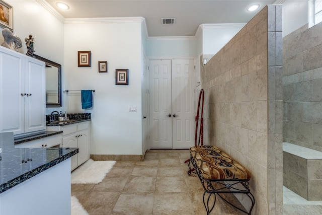 bathroom featuring tile patterned floors, vanity, ornamental molding, and walk in shower