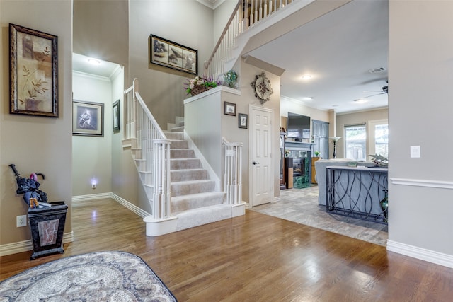 interior space with light wood-type flooring, ceiling fan, and ornamental molding