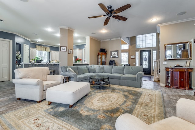 living room featuring light hardwood / wood-style floors, ceiling fan, and crown molding