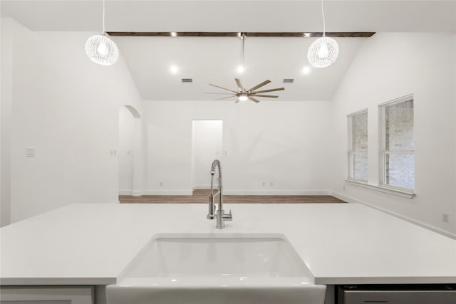 kitchen featuring stainless steel dishwasher, sink, pendant lighting, and lofted ceiling