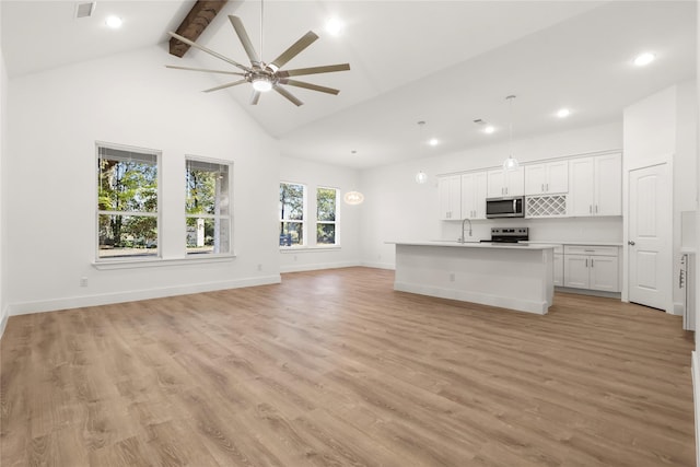 unfurnished living room with light wood-type flooring, ceiling fan, sink, beam ceiling, and high vaulted ceiling