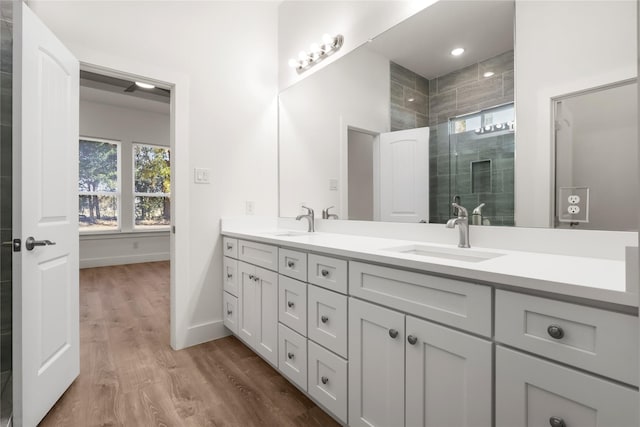 bathroom with hardwood / wood-style flooring, vanity, and an enclosed shower