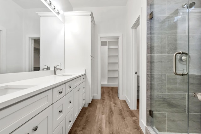 bathroom featuring hardwood / wood-style floors, vanity, and a shower with shower door