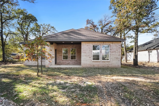 back of property with a yard and a patio