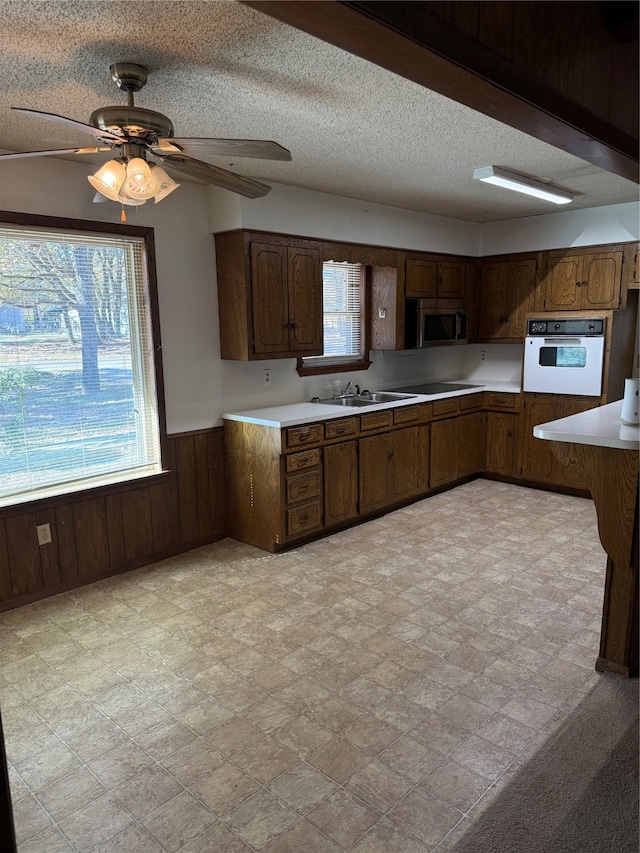 kitchen featuring dark brown cabinetry, oven, and a textured ceiling