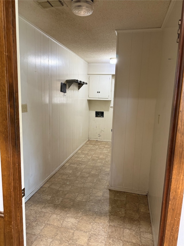 hall featuring wood walls and a textured ceiling