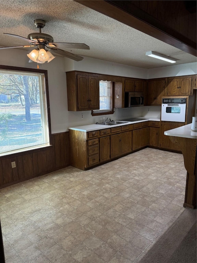 laundry room featuring hookup for an electric dryer, cabinets, and wood walls