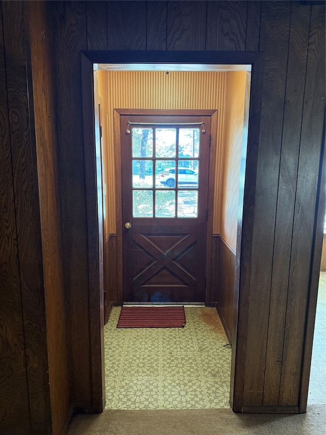 doorway to outside featuring wood walls