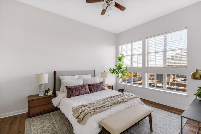 bedroom featuring multiple windows, hardwood / wood-style floors, and ceiling fan