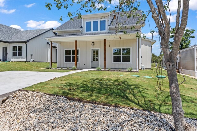 modern farmhouse style home with covered porch and a front yard