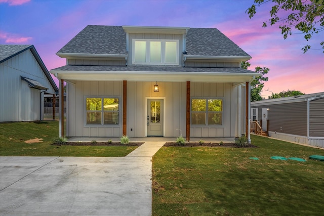 view of front of home with a porch and a lawn