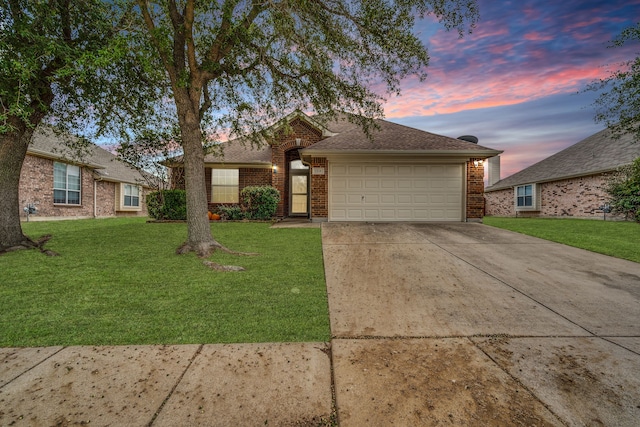 ranch-style home featuring a garage and a lawn