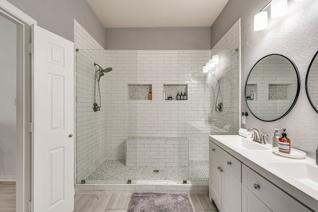 bathroom featuring a tile shower and vanity