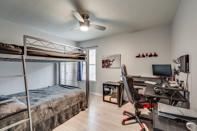 bedroom featuring wood-type flooring, a textured ceiling, and ceiling fan