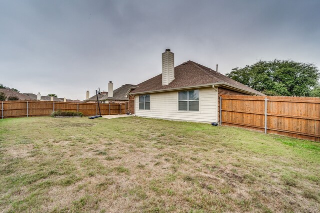 rear view of property featuring a lawn