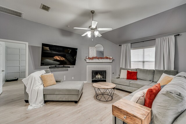 living room with lofted ceiling, light wood-type flooring, and ceiling fan