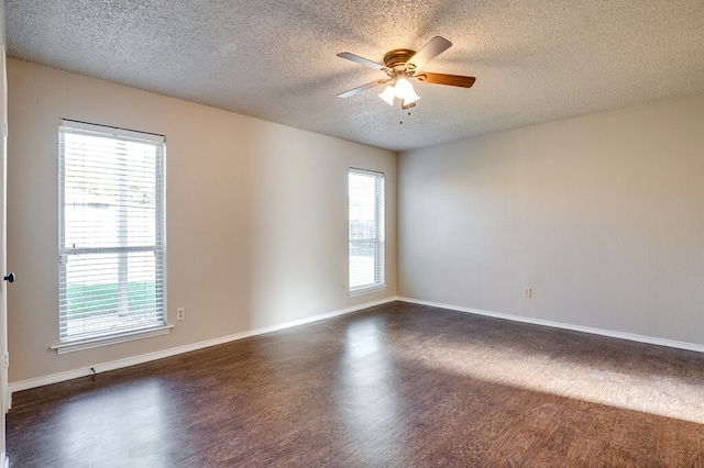 unfurnished room featuring a textured ceiling, ceiling fan, plenty of natural light, and dark hardwood / wood-style floors