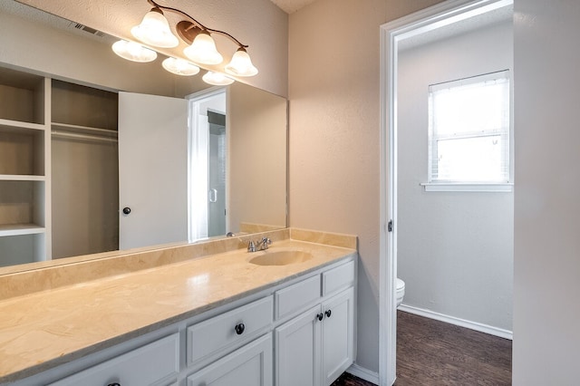 bathroom featuring toilet, vanity, a textured ceiling, and hardwood / wood-style flooring