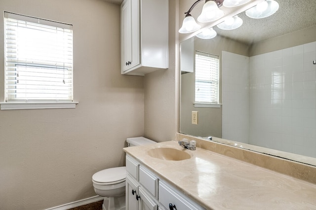 bathroom featuring vanity, a textured ceiling, and toilet