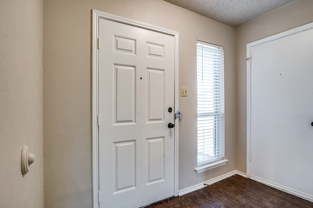 entrance foyer with dark hardwood / wood-style flooring and a textured ceiling