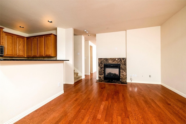 unfurnished living room featuring dark hardwood / wood-style floors and a premium fireplace