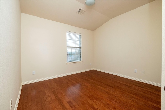 spare room with dark hardwood / wood-style floors and vaulted ceiling