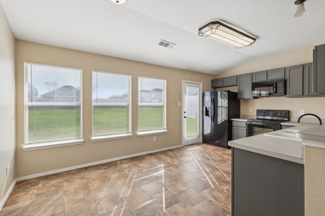 kitchen featuring gray cabinetry, sink, black appliances, and lofted ceiling