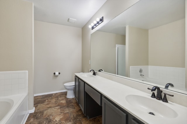 bathroom with vanity, a washtub, and toilet