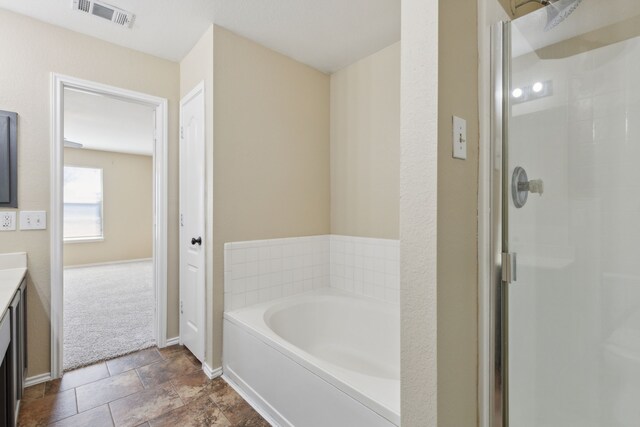 bathroom featuring vanity and independent shower and bath