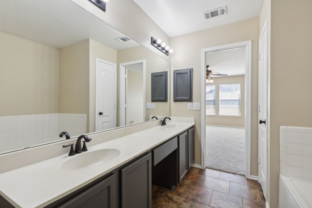 bathroom with vanity, a bathing tub, and ceiling fan