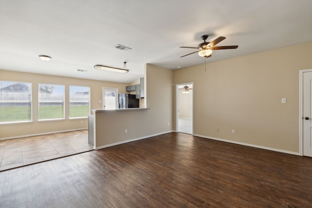 unfurnished living room with dark hardwood / wood-style floors and ceiling fan