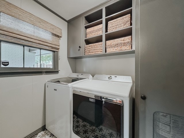 laundry area featuring washer and dryer, cabinets, and ornamental molding