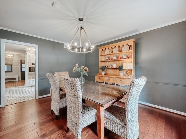 dining room featuring a chandelier, dark hardwood / wood-style floors, and ornamental molding