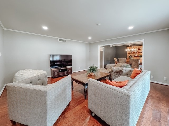 living room with a chandelier, wood-type flooring, and ornamental molding