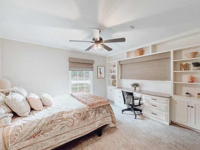 carpeted bedroom with ceiling fan and built in desk