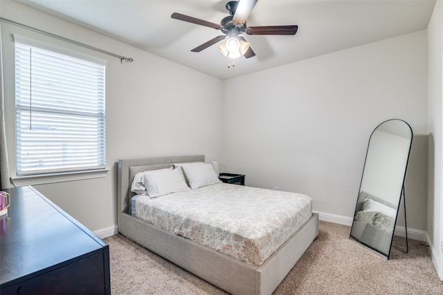 bedroom with ceiling fan and light carpet