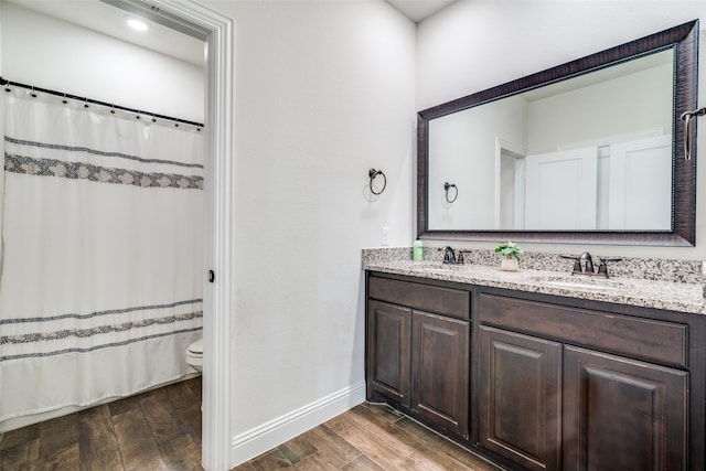 bathroom featuring hardwood / wood-style floors, vanity, curtained shower, and toilet