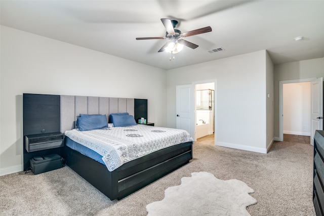 bedroom with light colored carpet, ceiling fan, and ensuite bathroom