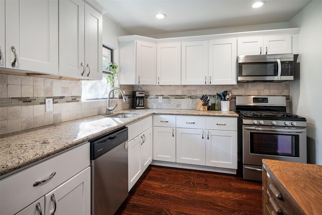 kitchen featuring light stone countertops, appliances with stainless steel finishes, sink, and white cabinets