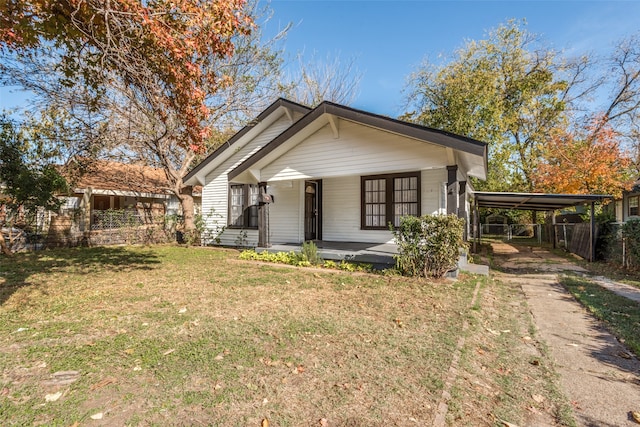 view of front of property featuring a front yard, a porch, and a carport