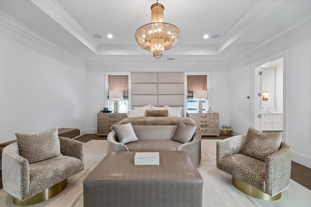 bedroom featuring a chandelier, ensuite bathroom, a raised ceiling, and wood-type flooring