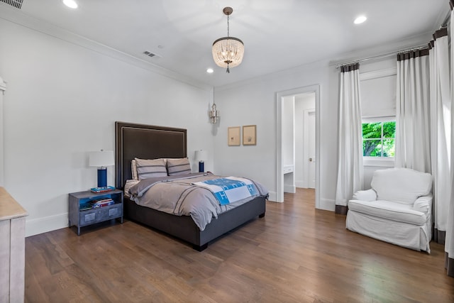 bedroom with crown molding, dark hardwood / wood-style floors, and an inviting chandelier