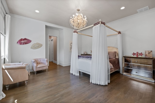 bedroom featuring dark wood-type flooring, ornamental molding, and a notable chandelier