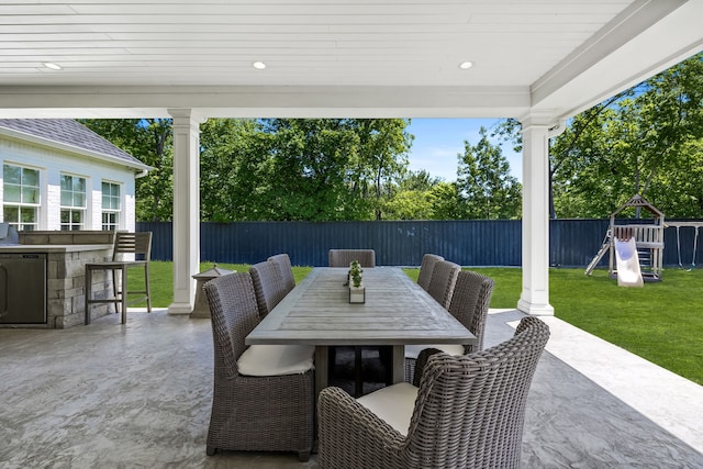 view of patio / terrace featuring a playground and exterior bar