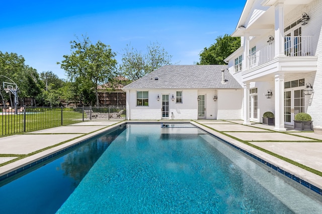 view of pool featuring a patio area, an outdoor structure, and a lawn