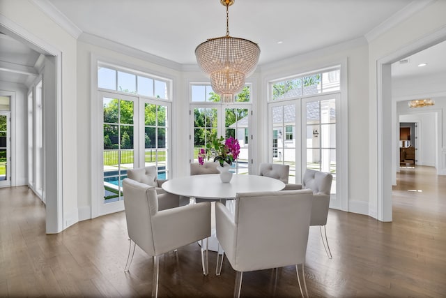 dining space featuring crown molding, a healthy amount of sunlight, and a notable chandelier