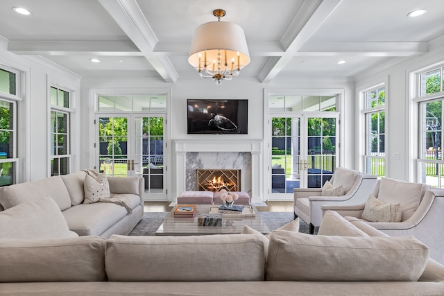 living room featuring beamed ceiling, a premium fireplace, coffered ceiling, and french doors